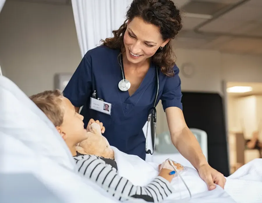 Nurse Smiling with Pediatric Patient in Hospital